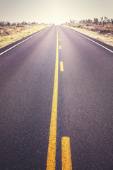 Road in the Joshua Tree National Park, focus on asphalt, color toned picture, USA.