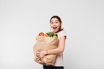 Portrait of an excited satisfied girl holding bag