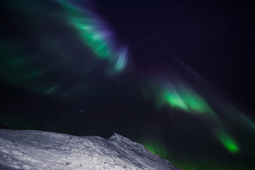 The polar arctic Northern lights aurora borealis sky star in Norway Svalbard in Longyearbyen city the moon mountains