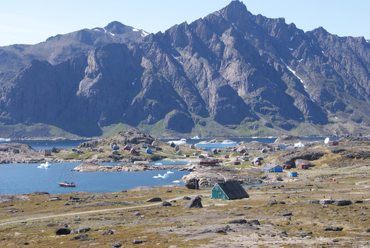 Greenland,: bay with an inuit village and a sailing boat
