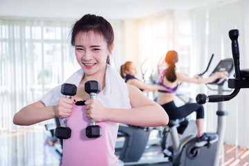 Fototapeta na wymiar asian strong woman fit and firm healthy concept lifting dumbbell at gym