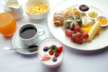 Rich continental breakfast. French crusty croissants, muesli, lots of sweet fruits and berries, hot coffee for morning meals.