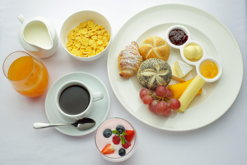 Rich continental breakfast. French crusty croissants, muesli, lots of sweet fruits and berries, hot coffee for morning meals.