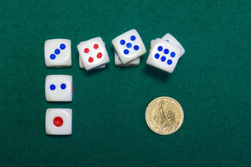 Dice and gold dollar on the green baize