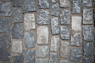 Stone pavement texture, granite cobblestoned pavement background, cobbled stone road regular shapes close-up