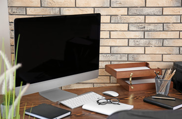 Comfortable workplace with computer monitor on table in office