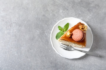 Plate with piece of delicious caramel cake on table