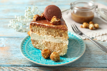 Plate with piece of delicious caramel cake on table
