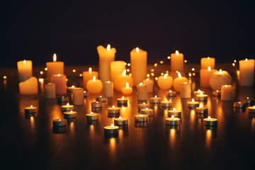 Burning candles on floor in darkness