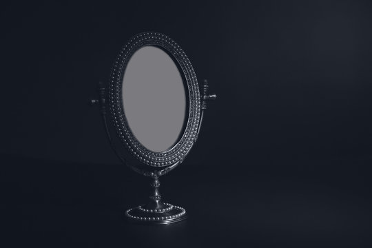 Vintage small mirror on black background