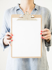caucasican woman showing clipboard with blank white paper