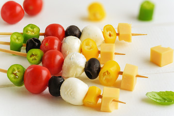 Appetizer on stick with various vegetables and cheese.