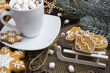 Christmas cookies on the sledges and hot chocolate with marshmallows  on the wooden background