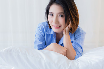 beautiful asian girl casual costume ralax on white bed next to window curtian with sunlight beauty skin concept