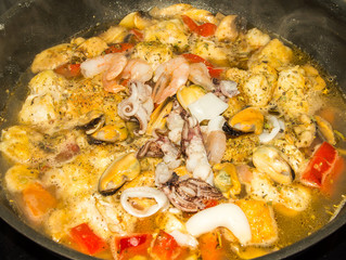 Seafood dish in pan on hob