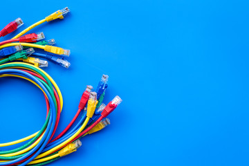 Network colored cables for computer on blue background top view copyspace