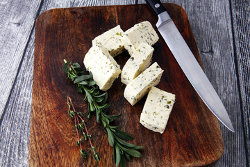Butter with thyme and rosemary and lemon zest. Sliced on a wooden board with herbs