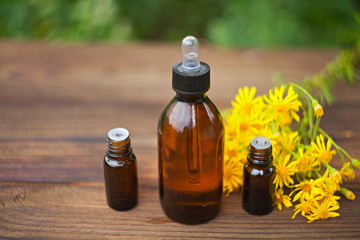 essential oil on table in beautiful bottle with flowers