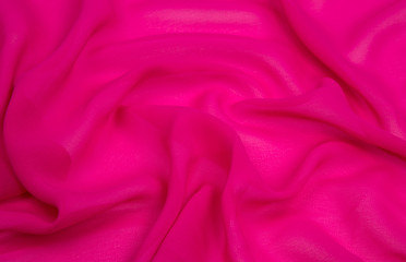 bright pink square and the light fabric spread out in soft folds on the table