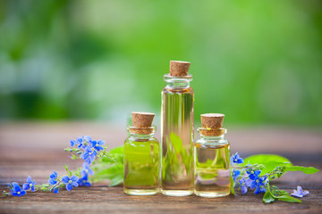 Essence of  flowers on table in beautiful glass Bottle