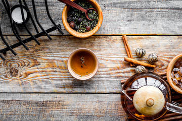 Tea ceremony concept. Tea pot, cups, dry tea leaves, sugar on rustic wooden background top view copyspace