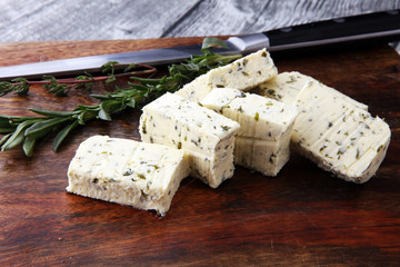 Butter with thyme and rosemary and lemon zest. Sliced on a wooden board with herbs