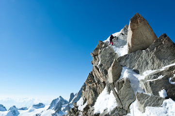 Climbing in Chamonix. Climber on the snowy ridge of Aiguille du Midi