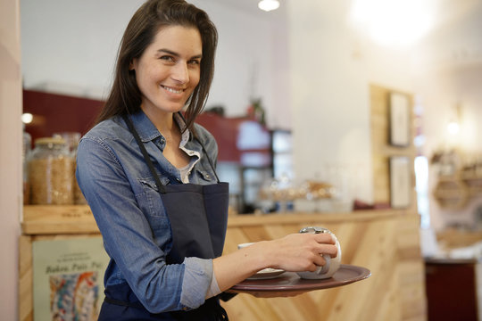 Waitress in coffee shop holding tray