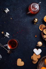 Teatime with heart-shaped ginger cookies and tangerines. Christmas background with festive decoration. Vertical composition