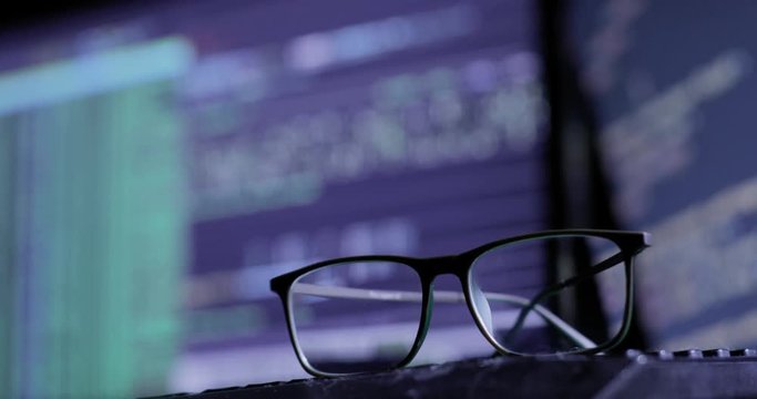 glasses on the keyboard, on the background of the monitor