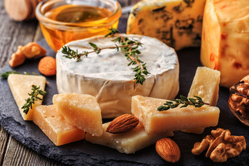 Cheese, nuts, honey and red wine on wooden background.