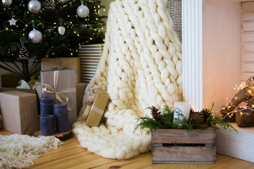 Beautiful holiday cozy room with Christmas tree, fireplace and white blanket