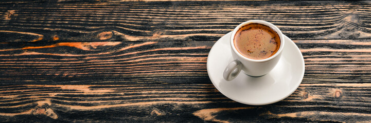 A cup of espresso coffee on a dark wooden background. Top view. Free space for text.
