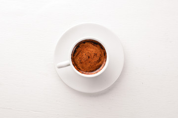 Espresso coffee cup on a white wooden background. Top view. Free space for text.