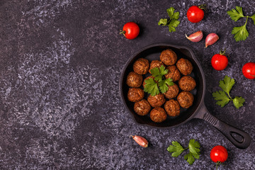 Roasted  meatballs with tomatoes, garlic and parsley.