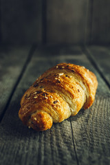 Crispy buttery croissants on old wooden table