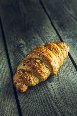Crispy buttery croissants on old wooden table