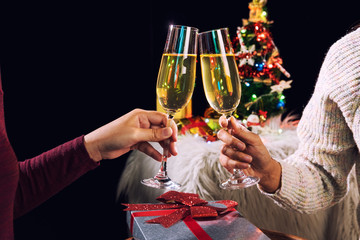 Beautiful two women holding glasses with champagne celebrating Christmas and gift boxes at corporate party, New Year Frame for your text