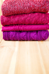 Obraz na płótnie Canvas Stack of warm pink, purple and violet cozy sweaters
