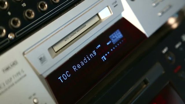 A woman inserts a mini disc into the player. Close-up