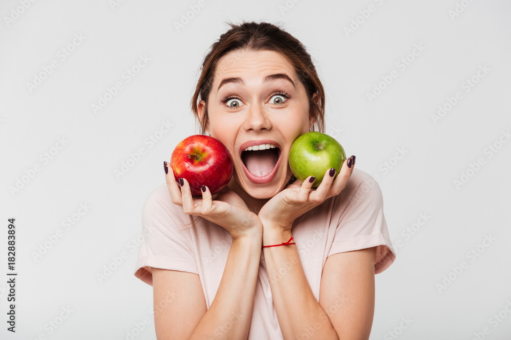 Wall mural Close up portrait of a happy pretty girl holding apples