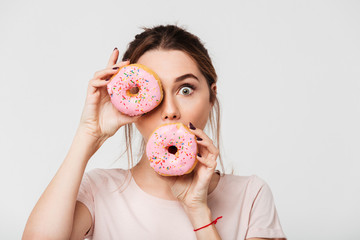 Close up portrait of a funny pretty girl holding donuts