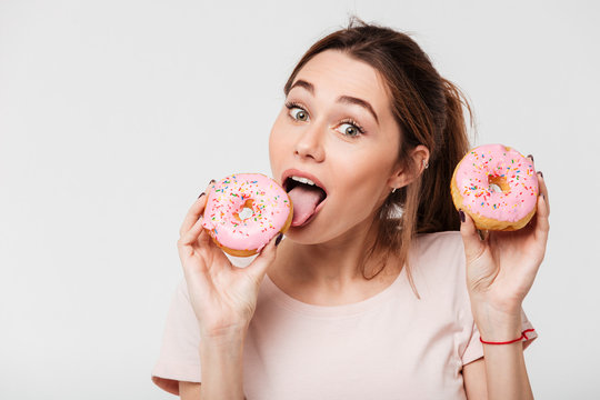Close up portrait of a happy pretty girl eating donuts