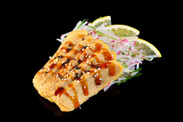 Japanese omelette sashimi over black background, concept menu of a Japanese restaurant