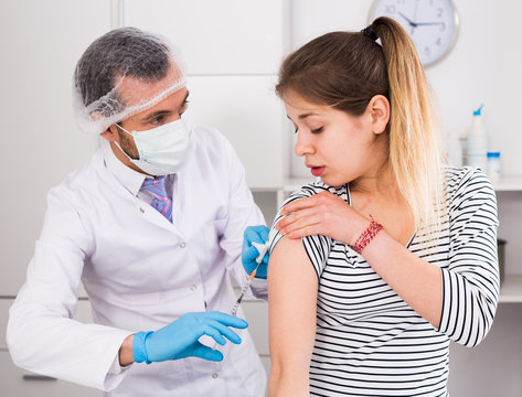Doctor vaccinating teenage patient