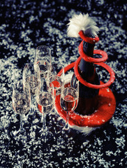 Celebrating new year, birthday, xmas party. Bottle of champagne in a bucket on black backgroud. Santa's hat