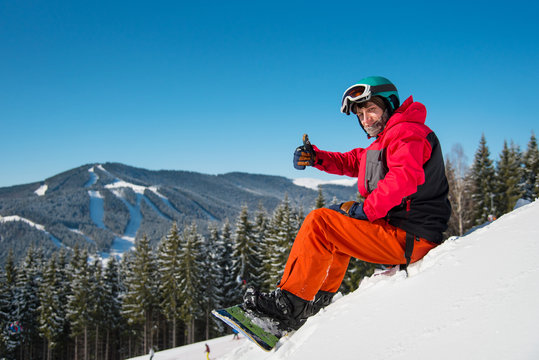 Shot of a happy snowboarder sitting, relaxing on top of the mountain, showing thumbs up to the camera copyspace extreme lifestyle activity hobby sportsman recreation travelling resort