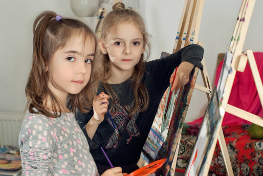 Children paint paint on canvas