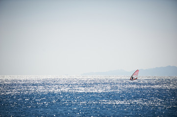 Windsurfing sail on the blue sea