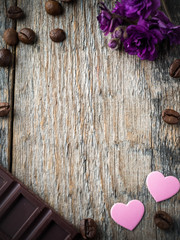 Decorations for Valentines day paper hearts, violets and chocolate coffee on rustic wooden background